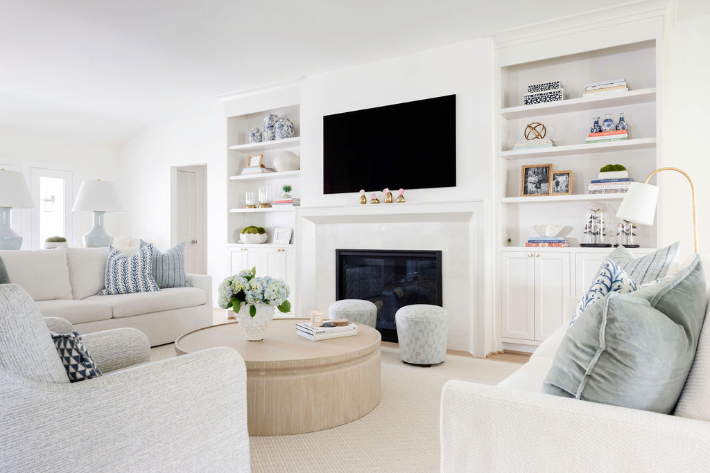 The family room got a total makeover! Say goodbye to that dark, cramped vibe—hello to an open, bright space that feels like a breath of fresh air. The fireplace? It's now the star of the show, flanked by sleek, custom cabinets and a chic modern mantle. We've decked out the room with super comfy, neutral furnishings that's perfect for chilling or entertaining. Soft blues and sage greens add just the right pop of color, while cute little brass accents bring in some stylish charm.