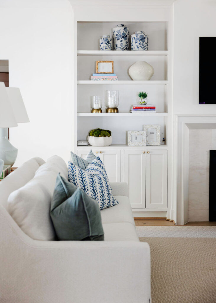 The family room got a total makeover! Say goodbye to that dark, cramped vibe—hello to an open, bright space that feels like a breath of fresh air. The fireplace? It's now the star of the show, flanked by sleek, custom cabinets and a chic modern mantle. We've decked out the room with super comfy, neutral furnishings that's perfect for chilling or entertaining. Soft blues and sage greens add just the right pop of color, while cute little brass accents bring in some stylish charm.