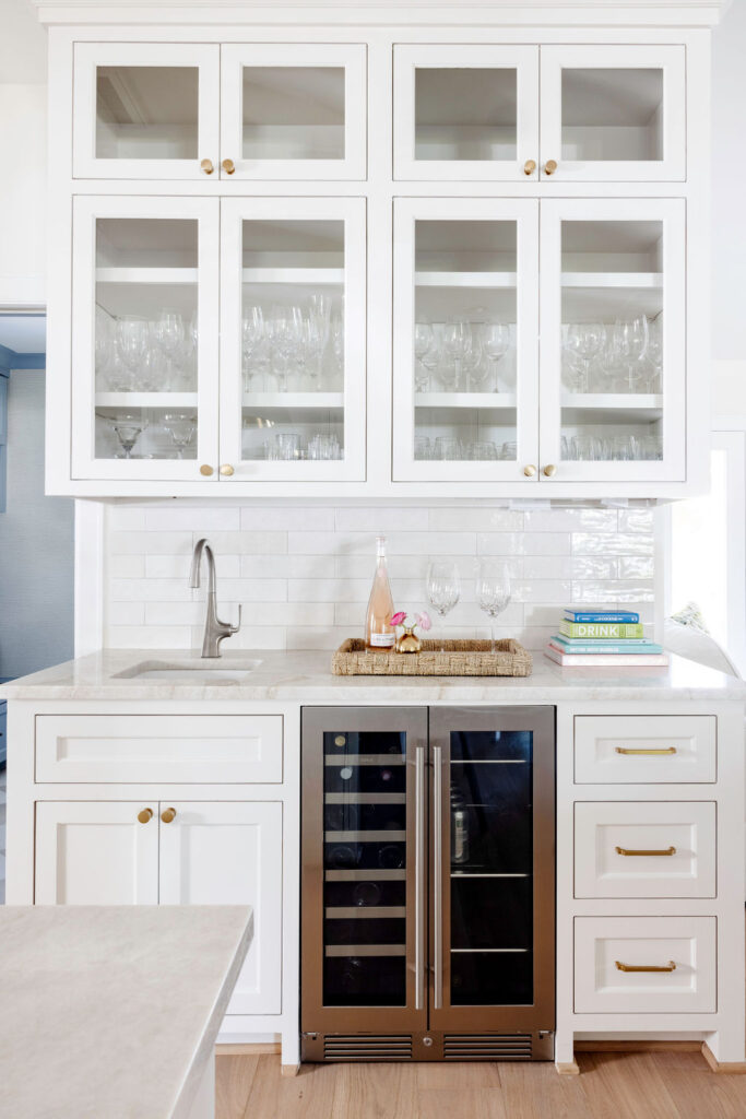 The kitchen, too, underwent a huge metamorphosis. They stripped away the dated cabinetry and replaced it with custom-built, soft neutral cabinets that offered both elegance and practicality. A spacious island became the heart of the kitchen, with a stunning slab of Taj Mahal quartzite that is truly a stunner. The subtle blend of countertops, textured backsplash and brass fixtures lent an air of sophistication without overwhelming the space.